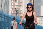 a woman riding a bike with a helmet on