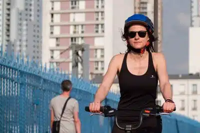 a woman riding a bike with a helmet on