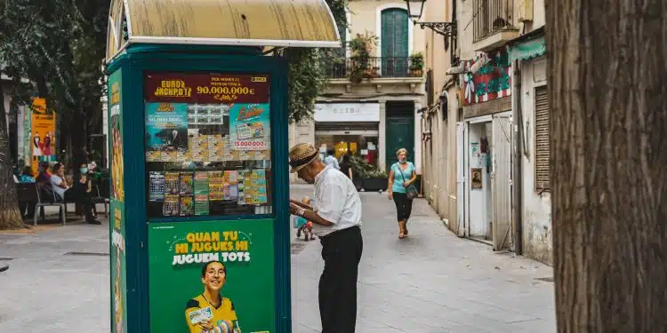 man in white dress shirt and black pants standing beside blue and yellow food stall