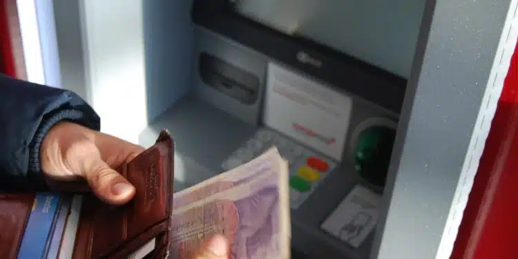 person holding brown leather wallet and banknotes