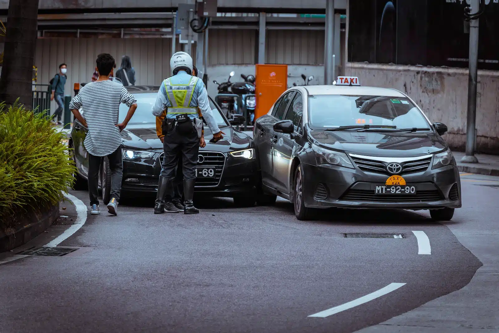 man in white and black stripe shirt and black pants standing beside black car during daytime